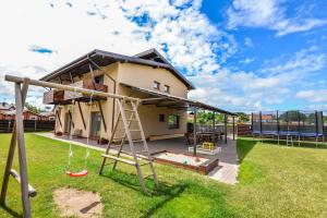 a house with a playground in the yard at Vasarnamiai in Šventoji