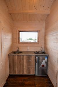 a kitchen with a sink and a stove in a cabin at Vasarnamiai in Šventoji +11 photos