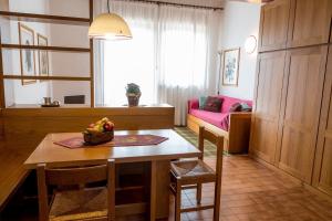 a kitchen and dining room with a table and a couch at Residence Des Alpes in Asiago