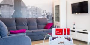 un soggiorno con divano e tavolo con libri di Apartment Milena a Danzica
