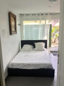 uma cama num quarto com uma janela em Asklan em Bormes-les-Mimosas