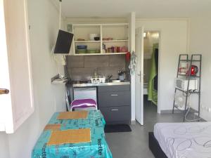 a small kitchen with a sink and a table in a room at Asklan in Bormes-les-Mimosas