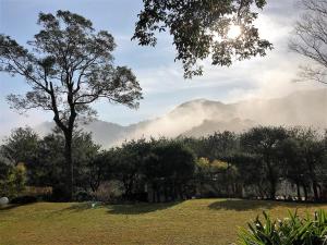 獅潭鄉的住宿－八角居所民宿，从带树的公园欣赏山景