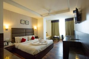 a hotel room with a bed and a desk at Hotel Sapphire in Chandīgarh