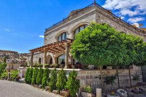 a building with a tree in front of it at Goreme Inn Hotel Only Adult in Göreme