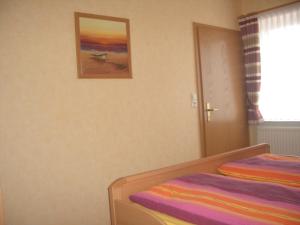 - une chambre avec un lit et une photo sur le mur dans l'établissement Haus Delphin, à Neuharlingersiel
