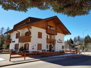 un edificio con balcones de madera en un lateral en Garni Biancaneve Ruffrè-Mendola en Mendola