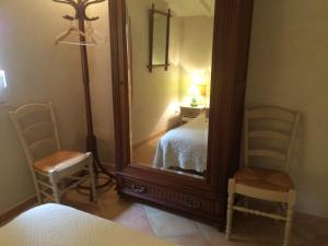 - une chambre avec un grand miroir et 2 chaises dans l'établissement Le Nid au Pied du Mont Ventoux, à Malaucène