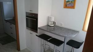a kitchen with a counter with two stools and a sink at Apartments Varos in Split
