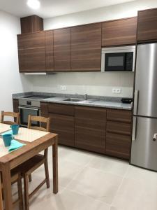a kitchen with wooden cabinets and a wooden table with a wooden table sidx sidx sidx at Soldouro Guesthouse in Aveiro