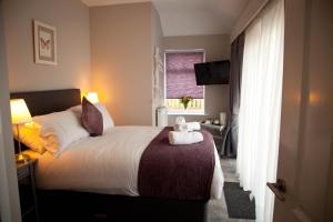 a hotel room with a bed with a stuffed animal on it at Rowton Poplars Hotel in Chester +15 photos