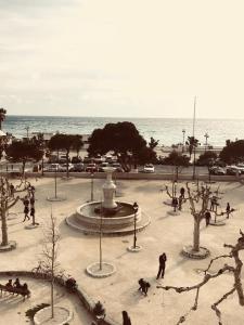 a group of people walking around a fountain near the ocean at Hôtel Liautaud Rooftop Cassis in Cassis