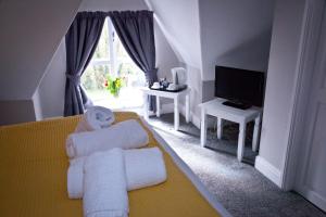 a living room with a yellow couch and a television at Rowton Poplars Hotel in Chester