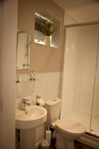 a white bathroom with a toilet and a sink at Rowton Poplars Hotel in Chester