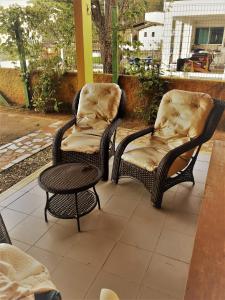 2 sillas de mimbre y una mesa en el patio en Casa Florianópolis, en Florianópolis