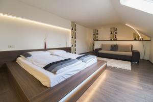 a bedroom with a large bed and a couch at Aranyudvar Apartman in Eger