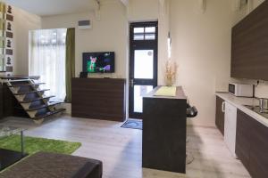 uma cozinha com um balcão e uma televisão num quarto em Aranyudvar Apartman em Eger