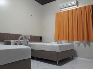 een ziekenhuiskamer met 2 bedden en een raam bij Hotel Pio in Teresina