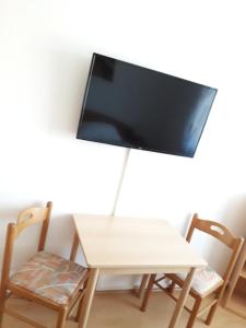 a table and chairs with a tv on a wall at Gästehaus Klug in Sankt Stefan ob Stainz