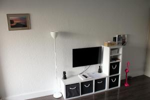 a living room with a tv on a white entertainment center at Studio 237 Port Camargue, Piscine, Climatisation, 2 personnes in Le Grau-du-Roi