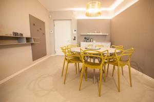 une salle à manger avec une table et des chaises jaunes dans l'établissement Murari Brà - Fiera Suite 01, à Vérone