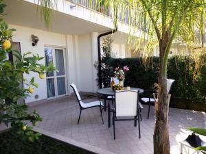 a patio with a table and chairs and a tree at Apartment Napitia Hills in Pizzo