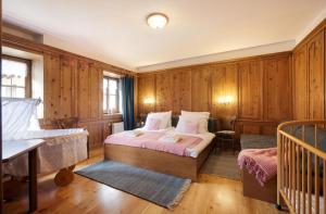 a bedroom with a bed and a crib in it at Chaletapartement Ambiente Villa Mozart in Chienes