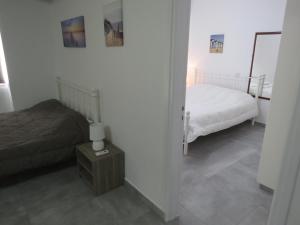 a bedroom with two beds and a table with a lamp at Adonis Apartment in Paphos