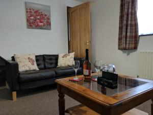 sala de estar con sofá y mesa con copas de vino en Kings Lodge en Telford