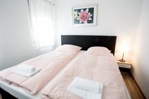 a bed with pink blankets and white towels on it at Waldheim in Nürtingen