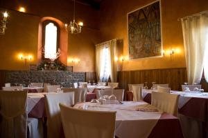 a dining room with white tables and chairs at La Magione in Serravalle Pistoiese