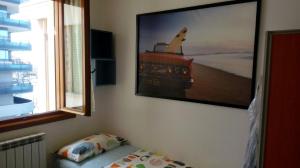 a bedroom with a picture of a boat on the wall at Appartamento Perco Riva Slataper in Grado
