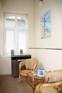 ソポトにあるBaltic Sopot 732の椅子2脚、テーブル、窓が備わる客室です。