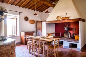 una cucina con tavolo e sedie in legno di Agriturismo Pieve Sprenna a Buonconvento