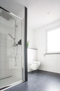 uma casa de banho com um chuveiro e um WC. em Waldheim em Nürtingen