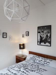 - une chambre avec un lit, une lampe et une photo dans l'établissement le 4bis, à Avignon