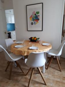una mesa de comedor con sillas blancas alrededor en le 4bis, en Aviñón