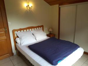 a bedroom with a bed with a blue blanket on it at L'Or de Fabiol in Orlu