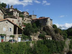 ein Dorf auf einem Hügel mit Häusern und Autos in der Unterkunft Les maisonnettes de bonneval in Jaujac