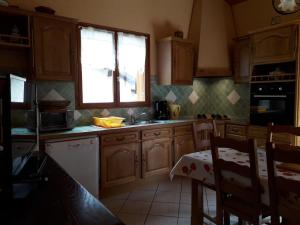 una cocina con armarios de madera y una ventana en L'Or de Fabiol, en Orlu