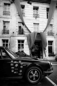 une voiture noire garée devant un bâtiment dans l'établissement Hôtel du Palais, à Angoulême