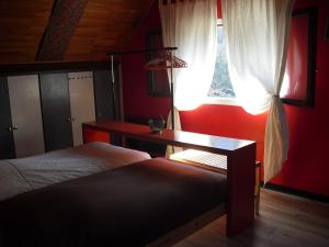 a bedroom with two beds and a desk and a window at La Maison Imparfaite in Fourbanne