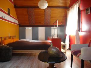 a bedroom with a bed and a table at La Maison Imparfaite in Fourbanne