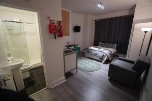 Una pequeña habitación con una cama y un baño. en London Queen Park Apartments, en Londres 139 fotos más