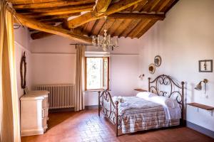 Schlafzimmer mit einem Bett und einem Fenster in der Unterkunft Agriturismo Pieve Sprenna in Buonconvento