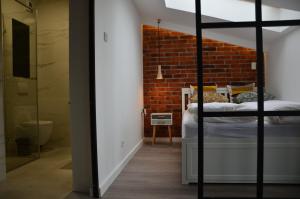 a bedroom with a brick wall and a bunk bed at Apartament Polka Dots in Krakow
