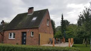 ceglany dom z drewnianym tarasem przed nim w obiekcie Ferienhaus Martha w mieście Fehmarn
