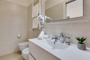 een badkamer met een wastafel, een toilet en een spiegel bij Rooms Vidar Train station in Marghera