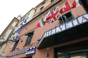 un bâtiment avec des drapeaux sur son côté dans l'établissement Hotel Helvetia, à Gênes