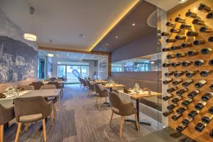 a restaurant with tables and chairs and wine bottles at Hotel du Commerce - Restaurant La Table de Clervaux in Clervaux